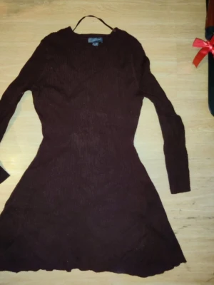 Brun stickad klänning Primark - Mysig brun stickad klänning från Primark i storlek XL. Klänningen har lång ärm, rund halsringning och en lätt utställd kjol. Perfekt för dig som gillar en enkel men snygg look.