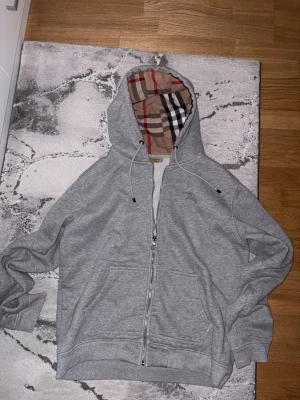 Grå zip hoodie från Burberry - Grå burberry kofta det passar mer som L men sitter bra på M. Byten går bra. Frakter ej möts upp bara!