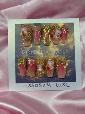 StrawberryKitty (M);Medium Ballerina - Handgjorda press-on naglar i rosa och nude med 3D-HK med jordgubbar och rosetter. Naglarna har guldiga detaljer och en glansig finish. Formen är i en medium längd och i ballerinaform. Designen är riktigt kwaii detaljerad och unik.M: 16 mm, 12 mm, 12,5 mm, 11,5 mm, 10 mm