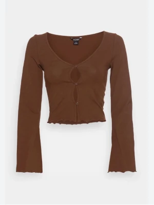 Brun långärmad topp med cut-outs - Trendig brun långärmad topp från Monki med två cut-outs framtill och dekorativa knappar. Croppad modell med vågig kant nertill och vid ärmslut. Tillverkad i mjukt stretchigt material som sitter snyggt på kroppen. Ny med prislapp. 
