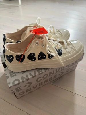 Converse x CDG Play vita sneakers -  Converse x Comme des Garçons Play sneakers. Jättefina skor som passar till allt! Perfekta till våren🥰 Dom är i storlek 6 UK, men skulle säga att de motsvarar storlek 39❣️Väldigt svåra att få tag på och ofta slutsålda!