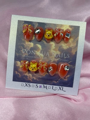 BearCharm (M);Short Almond - Handgjorda press-on naglar i orange nyans med glitter, dekorerade med 3D-detaljer som (Nalle Puh) gula björnhuvuden, kristll blomma/fjäril och holo rosetter. Naglarna har en kort almond form och är perfekta för dig som vill sticka ut.M: 16 mm, 12 mm, 12,5 mm, 11,5 mm, 10 mm