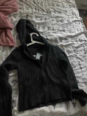 Mörkgrå hoodie med dragkedja 157 - Mysig mörkgrå hoodie från 157 med dragkedja framtill och ribbad struktur. Aldrig använt 