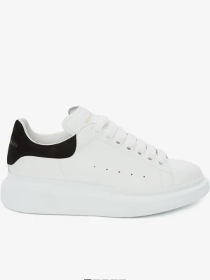 Alexander McQueen vita sneakers - Stilrena vita sneakers från Alexander McQueen med svart hälparti och tjock sula. Skorna har snörning och är tillverkade i skinn, med klassisk rund tå och minimalistisk design. Perfekta för dig som gillar en clean och trendig look.
