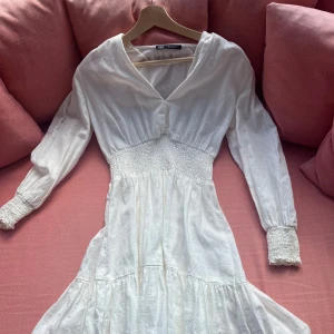 Vit klänning från Zara - Fin vit klänning från zara i storlek Xs som vara använts en gång Fin till många tillfällen och dotterdotter speciellt med den lite tajtare midjan