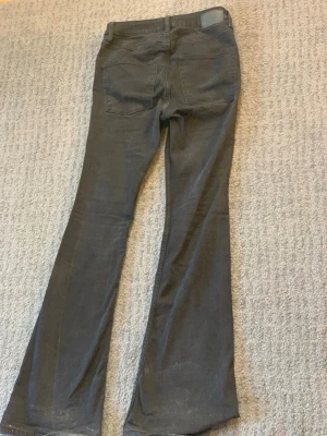 Svarta bootcut jeans från 157 - Säljer ett par svarta bootcut jeans från 157 med klassisk femficksdesign och utsvängda ben. Jeansen har normal midja och är tillverkade i ett mjukt denimtyg som sitter snyggt. Perfekta för dig som gillar en retroinspirerad look.