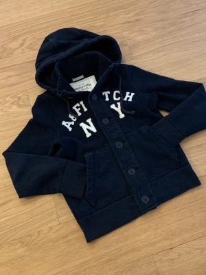 Abercrombie & Fitch cardigan - Säljer en sjukt snygg Abercrombie & Fitch Cardigan. Denna är sjukt eftertraktad och väldigt grisch och archive. Storleken är S. Skicket 10/10. Priset kommer vara 1099kr men kan sänkas.