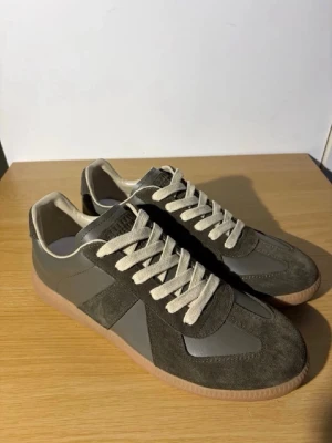 Grå sneakers med mockadetaljer - Snygga gröna  maisons i storlek 43. Aldrig använda  skriv vid funderingar, fraktar inom 24h ✅OBS använda nån gång efter bilderna togs. 