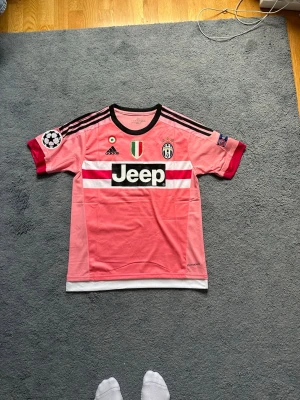 Paul Pogba Juventus Bortaställ 2015/16 - En riktig nostalgitripp tillbaka till Paul Pogba’s golden days i Juventus 2015/16 när de bar den ikoniska rosa bortatröjan. Tröjan kommer även med Champions League och Repspect patch. Helt oanvänd och i sprillans nytt skick. Storlek M. Pris är inte diskutabelt.