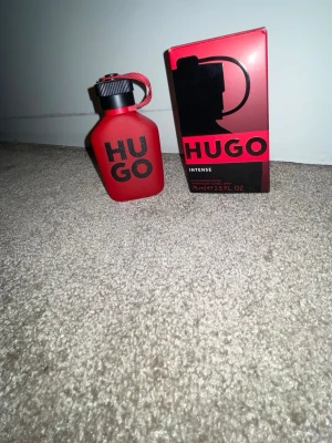 Hugo Boss parfym 75ml. Använt max 10 sprays - NYPRIS 700kr   Säljer Hugo Boss Bottled Intense Eau de Parfum 75 ml. Använd max ca 10 sprays, nästan full flaska och original box finns. Doften luktar varm äpple och kanel i början, går över i träiga och kryddiga toner och blir mjuk och lite söt i basen med vanilj och trä. Passar till kvällar, dejter och kallare dagar. Skick väldigt bra, nästan som ny. Fick den av min mormor för nästan ett år sedan.  På bild nr 3 ser man vätskan 