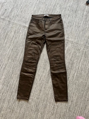Tommy hilfiger Bruna skinny jeans med hög midja - Snygga bruna skinny jeans med hög midja och klassisk femficksdesign. Jeansen har smal passform och är perfekta för dig som gillar en stilren look. Materialet är stretchigt för extra komfort och rörelsefrihet. Mått 28/32