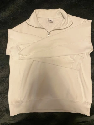Vit halvzip tröja från Zara - Snygg vit halvzip tröja från Zara med hög krage och dragkedja. Mjuk insida och raka ärmar, perfekt för lager-på-lager. 