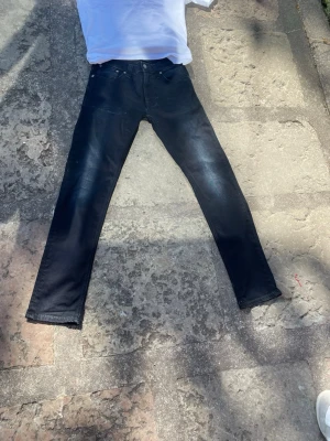 Nudie Svarta slimfit jeans  - Snygga svarta slim fit jeans med klassisk femficksdesign och diskreta fades på låren. Jeansen har smal passform och normal midja, perfekta för en trendig och stilren look.