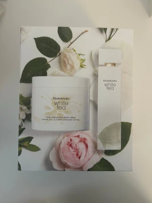 Elizabeth Arden White Tea parfymset - Parfymset från Elizabeth Arden med doften White Tea. Setet innehåller en Eau de Toilette spray (100 ml) och en body cream (400 ml). Förpackningen är vit med eleganta blommotiv och produkterna har en stilren, modern design. Helt oanvända och är i sin orginalförpackning. 