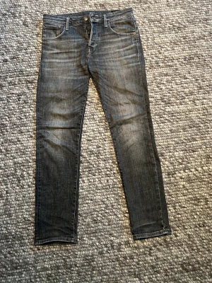 Mörkgrå slim fit jeans - Snygga mörkgrå slim fit jeans med klassisk femficksdesign och diskreta slitningar framtill. Jeansen har raka ben och normal midja, perfekta för en stilren och avslappnad look. Materialet är mjukt denim med lite stretch för extra komfort. Storlek W31 L32. Ny pris 1000kr