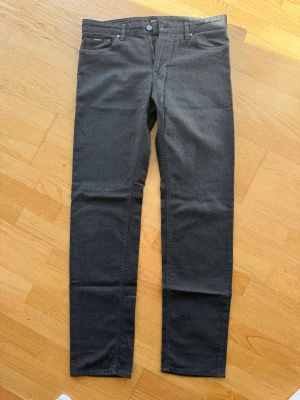 Stretchig byxa/jeans i grått från BOSS  - Grå 5 ficks byxa/jeans från BOSS. Knappen i midjan är lös och kan lätt ersättas med en vanlig knapp. 