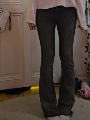 Mörkgrå bootcut jeans - Säljer ett par mörkgrå bootcut jeans med klassisk femficksdesign och snygg passform. Jeansen har en lätt utsvängd benform och är tillverkade i denim med stretch för extra komfort. Perfekta för dig som gillar en trendig och avslappnad look.