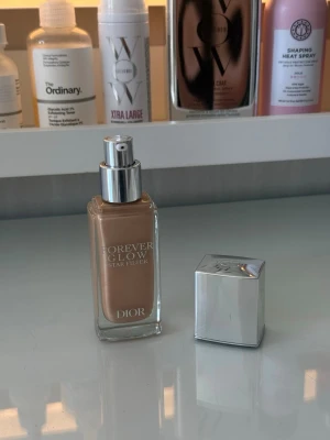 Dior Forever Glow Star Filter foundation - Säljer en Dior Forever Glow Star Filter foundation i glasflaska med silvrig pump och lock. Färgen 3N med varm underton. Flaskan har elegant design och ger ett lyxigt intryck, perfekt för dig som vill ha en naturlig glow och jämn hudton. Jag har endast använd den en gång så den är inte oren elller så. Det enda är att pumpen sitter lite löst men den pumpar ut som den ska. Originalpris från kicks:629 kr. 