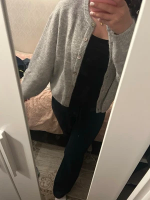 Grå kofta med knappar - Mysig grå kofta från Gina i storlek S med rund hals och knäppning framtill. Koftan har en enkel och stilren design med långa ärmar och ribbade mud. Säljer då jag inte använder den