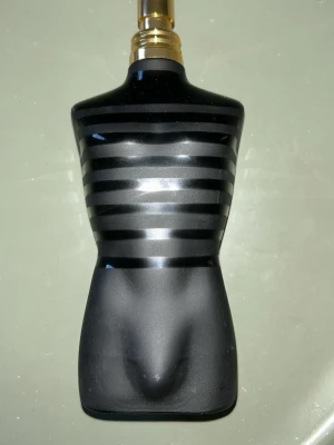 Jean Paul Gaultier Le Male parfym - Säljer en ikonisk parfymflaska från Jean Paul Gaultier, Le Male. Flaskan är formad som en manlig torso i svart glas med matta och blanka ränder samt guldfärgad spraytopp. Perfekt för dig som gillar unika och snygga parfymflaskor.