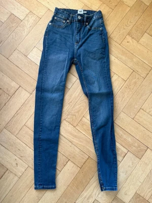 Mörkblå skinny jeans hög midja - Snygga mörkblå skinny jeans med hög midja och klassisk femficksdesign. Jeansen har smal passform och är tillverkade i stretchigt denimtyg för extra komfort. Från Lager 157 i modellen Snake. 