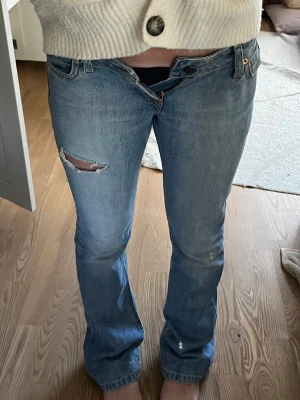 Blå lågmidjade bootcut jeans från Levi's - Säljer ett par jättesnygga lågmidjade jeans från Levi’s som tyvärr har blivit för små. De är i strl w24 men längden vet jag inte. Som prefferens är jag 165 och passar i längden bra ⭐️