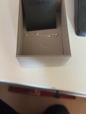 Silverfärgat armband från Pilgrim - Snyggt och stilrent armband från Pilgrim i silverfärg. Armbandet har en tunn kedja med små pärldetaljer som ger en elegant touch. Perfekt accessoar för att lyfta din outfit. Äkta silver och helt nytt.