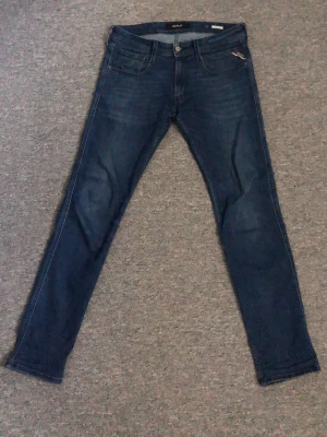 Mörkblå slim fit jeans från Replay - Lite schysstare blå Replay Anbass jeans från replay W31  L32. Typ 90% bomull o grejer 8% polyester 2% elastan. Använda ca 7 månader. Enda skadan är lite tråd som lossnat som du ser annars jättebra. Fråga om ni undrar nåt.