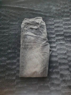 Grå Jeans - Säljer ett par mörkgrå jeans. Jeansen har en snygg tvättad look och raka ben. Perfekta för dig som gillar en avslappnad men silren vibe.