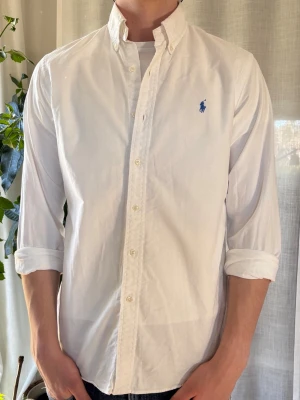 Vit skjorta från Polo Ralph Lauren - Klassisk vit skjorta från Polo Ralph Lauren med blå broderad logga på bröstet. Storlek L