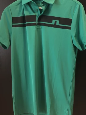 Grön piké från J.Lindeberg - Snygg grön pikétröja från J.lindeberg, perfekt till golfrundan eller bara för att sätta lite färg i vardagen! S men passar M