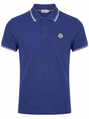 Blå polotopp från Moncler - Snygg blå polotopp från Moncler med klassisk krage och korta ärmar. Toppens krage och ärmslut har vita ränder för en sportig look. Materialet är bomull och passformen är normal. Moncler-loggan sitter på bröstet.