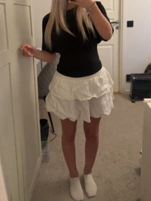 Vit volangkjol med lager - Säljer vit kortkjol med flera volanglager i storlek Petite XS från Shein. Den är jättefin och passar till både enkla och mer uppklädda outfits. Säljer pga att den inte är min stil så den används ej. 