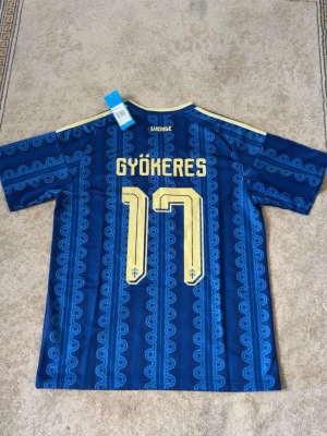 Sverige fotbollströja borta VM - Blå Sverige fotbollströja från Adidas    Borta tröja inför VM jätte lågt pris med jätte bra kvalite. Om du är intresserad av fler tröjor checka profilen. Fraktar direkt vid köp! Storlek M 