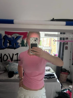 Rosa stickad topp från Zara - Säljer en söt rosa stickad topp från Zara med korta ärmar och rund halsringning. Tröjan är i mjukt material och har en figurnära passform som passar perfekt till både jeans och kjol.