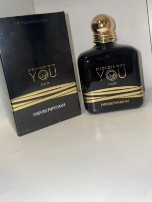 Emporio Armani Stronger With You Oud - Emporio Armani Stronger With You Oud är en exklusiv parfym i svart glasflaska med gulddetaljer och rund guldfärgad kork. Doften är intensiv och lyxig, perfekt för dig som gillar unika och djupa doftnoter. Flaskan rymmer 100 ml och har en elegant design.