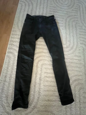 Svarta skinny jeans herr - Säljer ett par svarta skinny jeans med klassisk femficksdesign och låg midja. Jeansen har smal passform hela vägen ner och är perfekta för en avslappnad streetstil. Materialet är stretchigt denim som ger bra komfort och rörelsefrihet. 