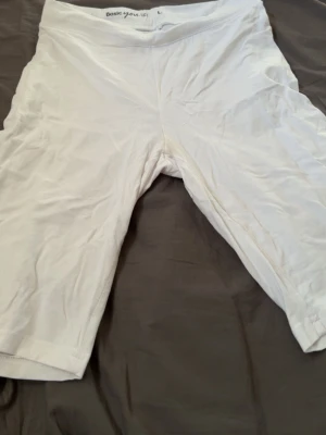 Vita cykelshorts från Basic You - Vita cykelshorts från Basic You i mjuk ekologisk bomull. De har en enkel och clean design med midja som sitter bekvämt. Perfekta för sommaren eller som basplagg under kjol eller klänning.