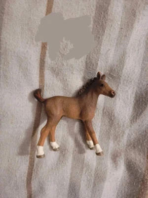 Brun hästfigur  - Säljer en brun hästfigur med vita detaljer på benen. Figuren har realistiska former och detaljerad man. Perfekt som dekoration eller leksak för hästälskare.