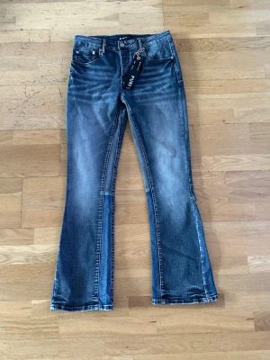 Blåa flared jeans från Purple  - Snygga blåa flared jeans från Purple Brand med coola färgstänk. 