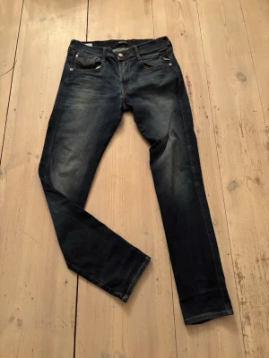 Replay Anbass slim jeans mörkblå - Säljer ett par Replay Anbass slim fit jeans i mörkblå tvätt. Storlek 32. Priset är inte hugget i sten!