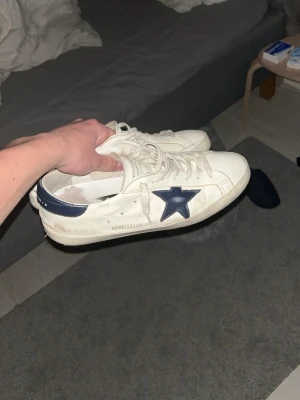Golden Goose vita sneakers med blå stjärna - Tja säljer nu mina otroligt stiliga och sköna golden goose skor. Otroligt fräscha och passar till nästan vilken outfit som helst. Priset är inte hugget i sten. De är bara att skriva om ni har några frågor eller funderingar 🙌 Mvh Oscar