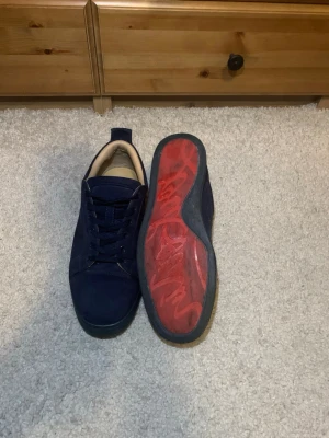 Christian Louboutin - Snygga mörkblå  Christian Louboutin i mocka med klassisk låg profil och blå skosnören. Knappt använda och har tagit hand om väl. Tyvärr ingen box till skorna. Skriv om du undrar nått om skorna.