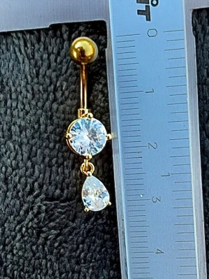 NY oanvänd Navelpiercing med hänge | Kirurgiskt stål | Vita stenar  - 💕30% Bundle-rabatt vid köp av minst 2 artiklar. ⭐️NY oanvänd piercing i kirurgiskt stål; rostfritt och säkert för läkta piercingar.                               📏MÅTT ⭕️Stavens längd: 10mm ⭕️Stavens tjocklek: 1,6mm  ⭕️Smyckets totala längd: 30mm                                                                         🤍Färger: Guld och vit                                                            💌Skickas spårbart via Plick SafePay.