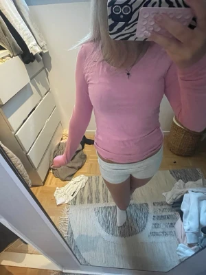 Ljusrosa långärmad topp - Säljer en ljusrosa långärmad topp med rund hals. Toppen har en slim passform och är perfekt för dig som gillar en enkel men söt stil. Materialet känns mjukt och stretchigt, troligtvis bomull eller en bomullsblandning.