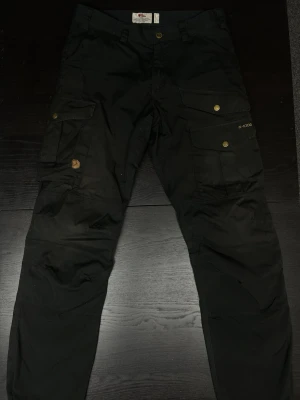 Fjällräven G-1000 byxor - Säljer svarta Fjällräven G-1000 byxor i storlek EU 46. Mått finns i bilderna. Använt skick, inga skador