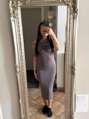 Taupefärgad långklänning från Zara - Taupefärgad figurnära långklänning med draperad halsringning. Stretchigt material och mycket fin passform. Fint skick. Storlek M men är som S