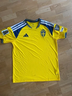 Sveriges VM hemma tröja 2026  - Säljer Sveriges hemma VM-tröja 2026 🇸🇪 Riktigt snygg i klassiska gula färgen med blå detaljer – en riktig supporterfavorit!  Storlek: 2XL Observera att den är liten i storleken. Har du normalt XL rekommenderar jag att gå upp 1–2 storlekar för bästa passform.  Tröjan är i helt nytt skick och aldrig använd. Först till kvarn👍