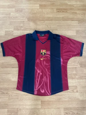 Barcelona  x Travis Scott retro tröja - Barcelona X Travis Scott retro tröja från föregående säsongen 24/25. På ryggen står det nummer 2 och Cactus Jack som är Travis egna varumärke. Passformen är Oversize. Helt ny!!
