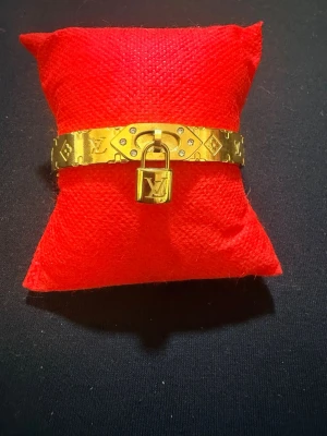  Snyggt guldarmband med lås - Elegant armband i guldpläterat rostfritt stål. Perfekt statement-piece för dig som gillar lyxiga accessoarer.